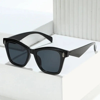 Cat-eye sunglasses with a glossy black frame, dark grey lenses, and retro rivet accents – Astroshadez