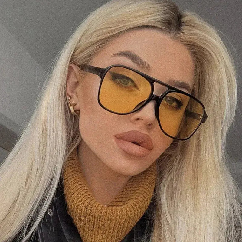 SHAUNA pilot sunglasses with oversized black frame and yellow lenses worn by a woman – Astroshadez